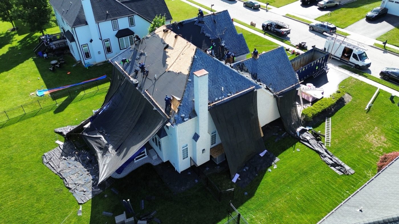 Aerial drone view of Shelby Roofing Services crew working on residential roof in PA