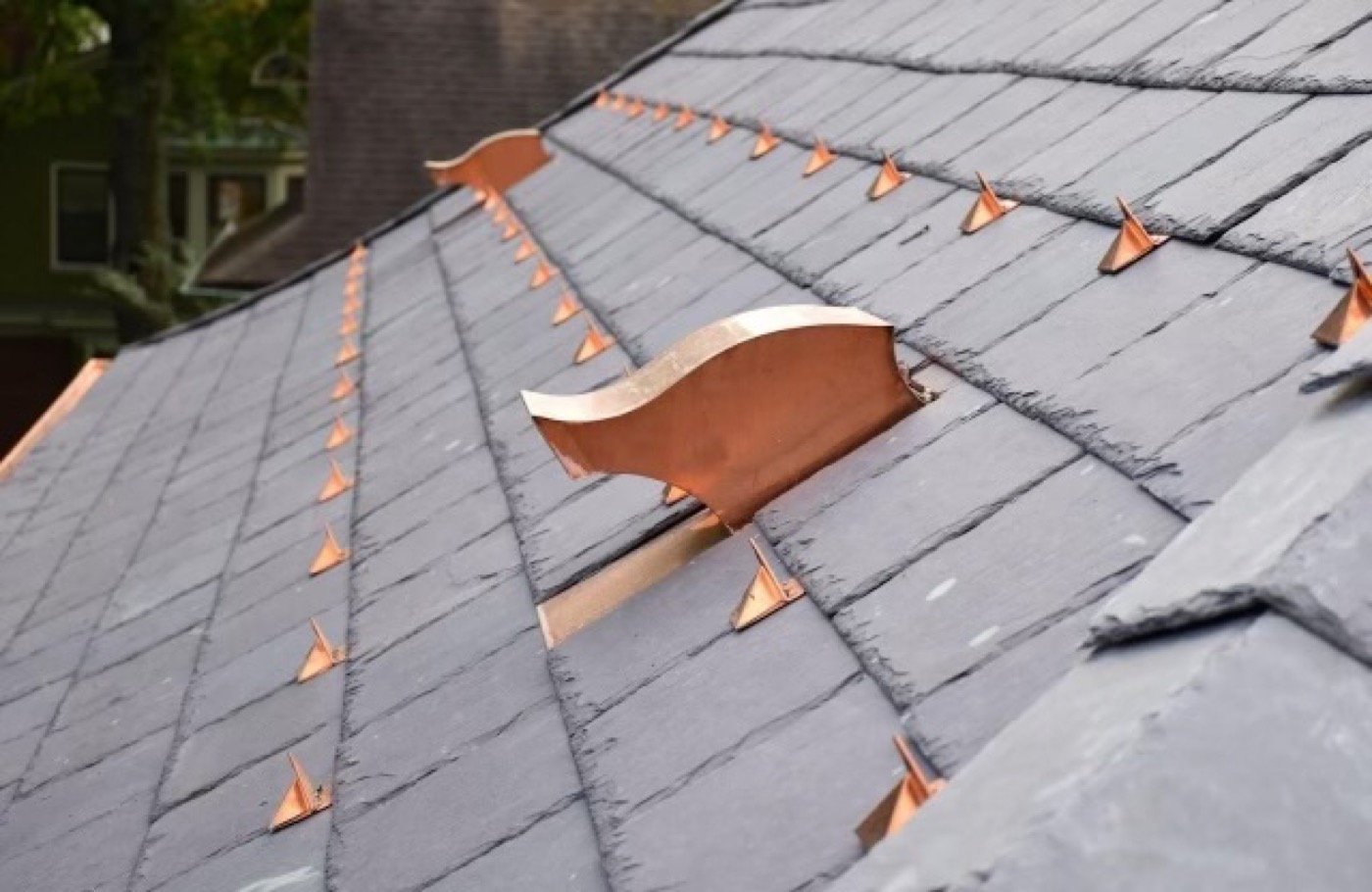 Copper snow guards and copper flashing detail on a natural slate roof — Shelby Roofing Services