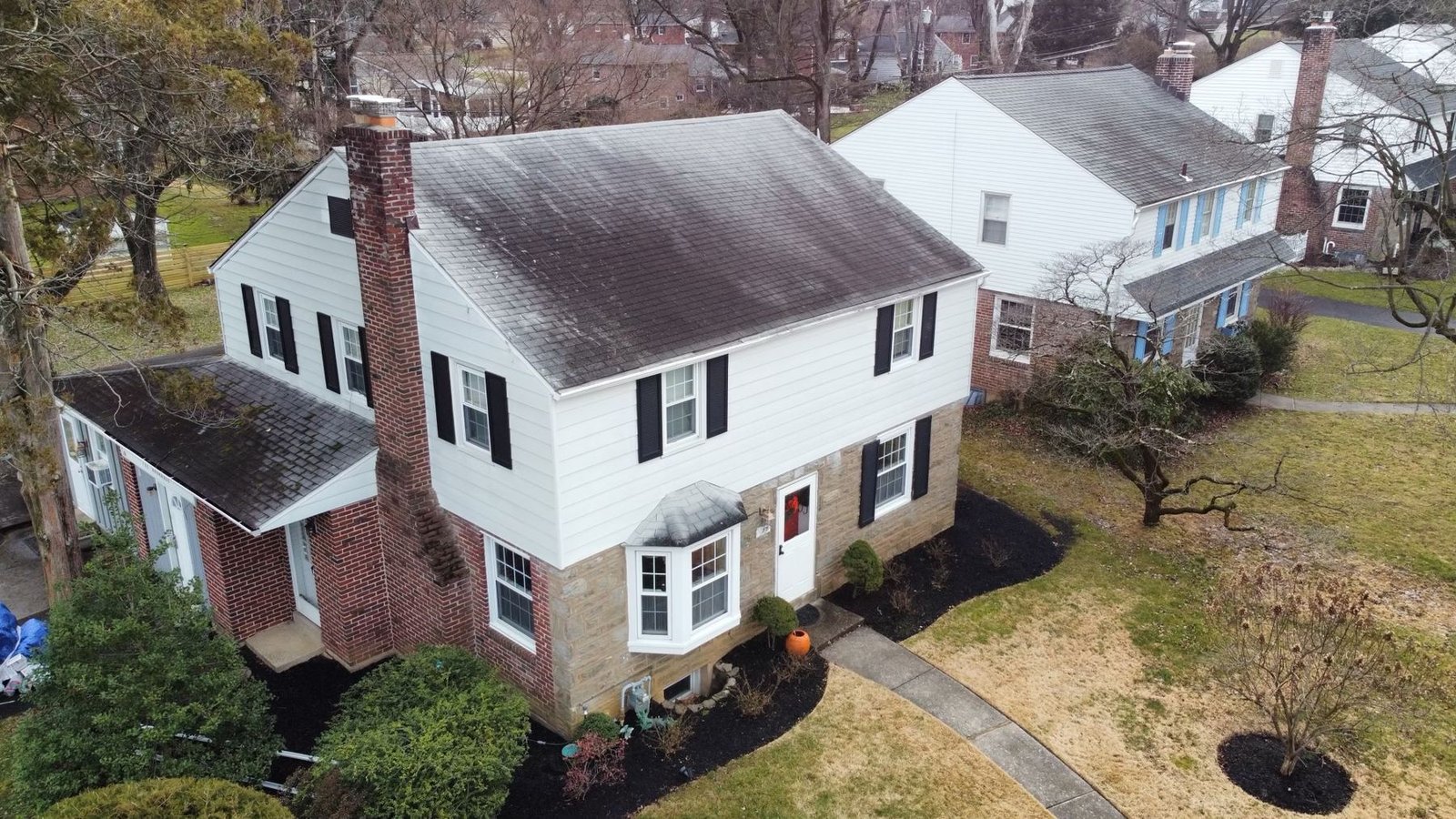 Before — front aerial view of colonial home with old dark shingle roof, PA