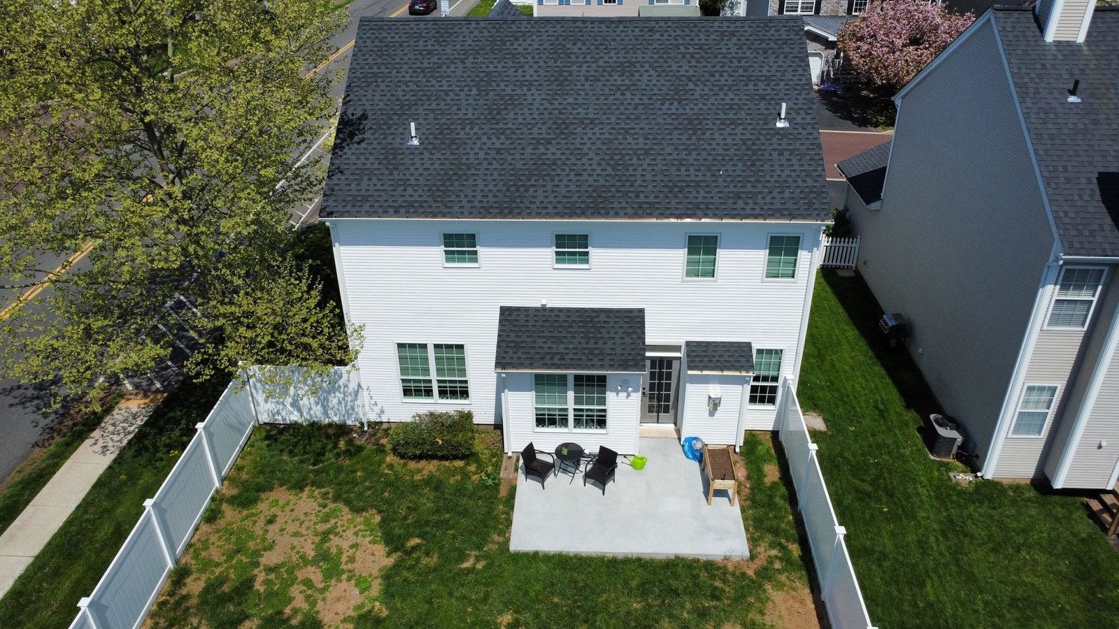 After — rear aerial of completed home showing new siding, roof, and backyard — Shelby Roofing Services PA