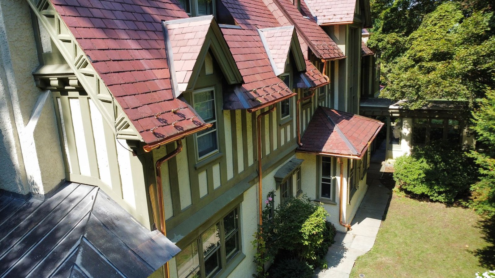 Completed — front of historic Tudor estate with new copper gutters and downspouts on slate tile roof — Shelby Roofing Services PA