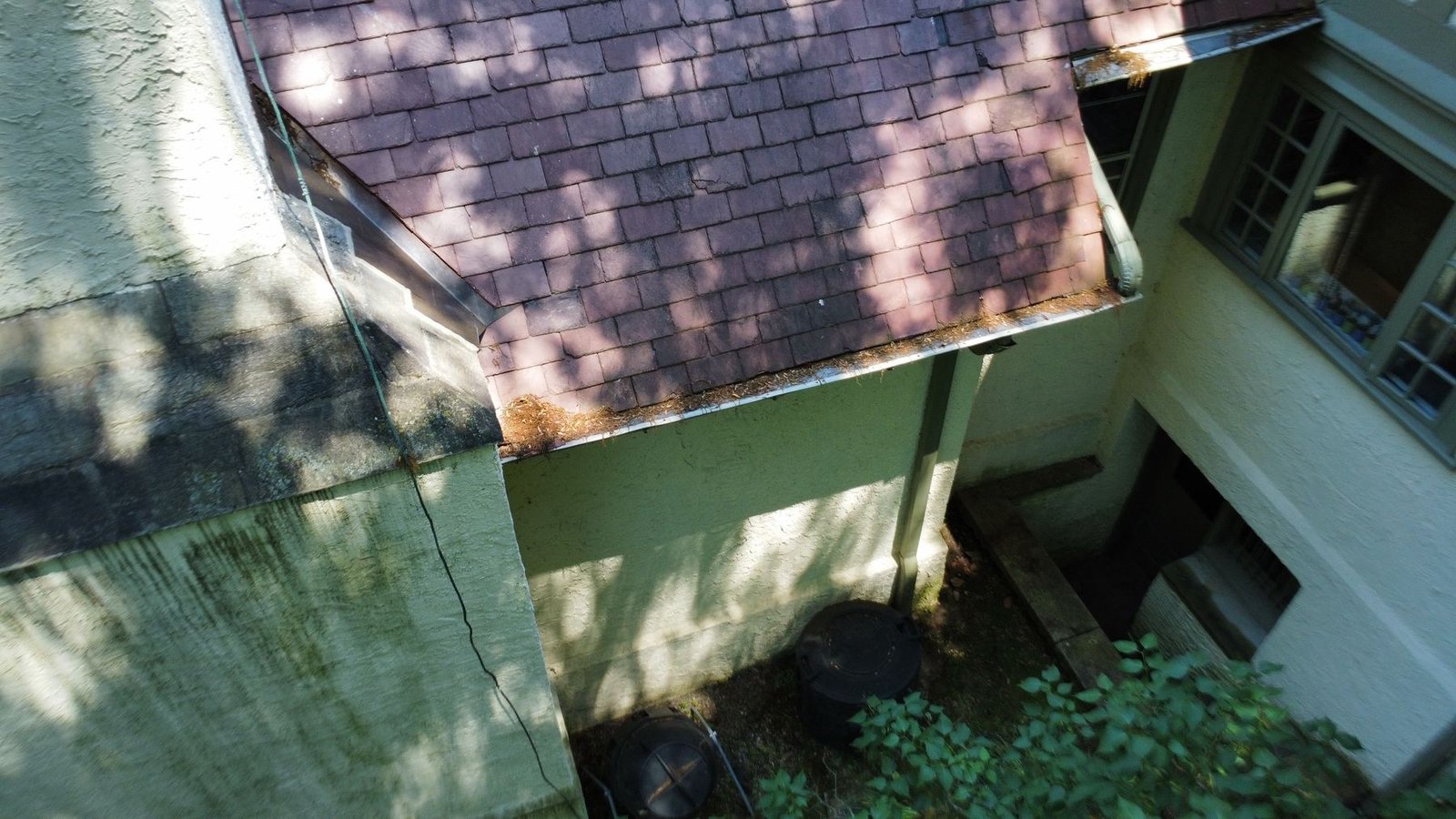 Before — close-up of debris-packed gutter section causing wall staining on Tudor estate, PA