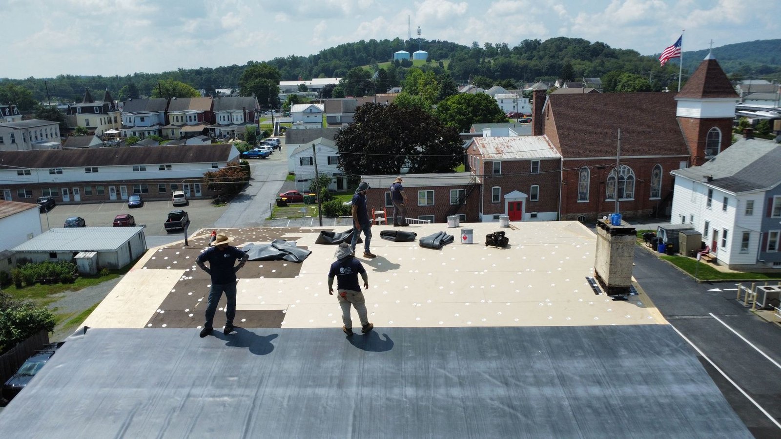 In-progress — Shelby Roofing crew installing new insulation boards and EPDM membrane on commercial flat roof, PA