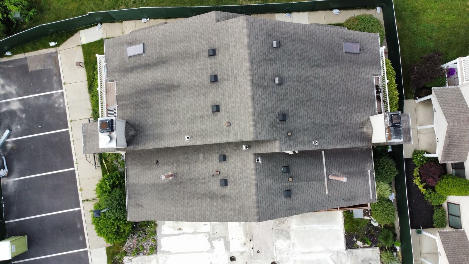 Before — top-down aerial of condo complex with storm-damaged algae-covered shingles, PA
