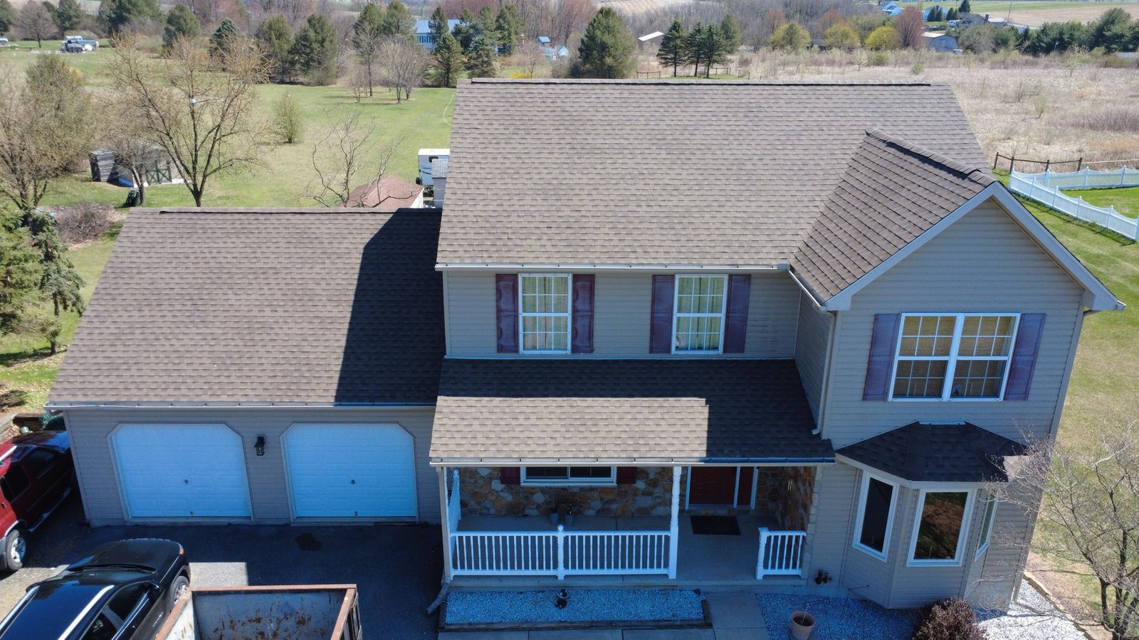 After — front facade of 2-story colonial with new brown shingles — Shelby Roofing Services PA
