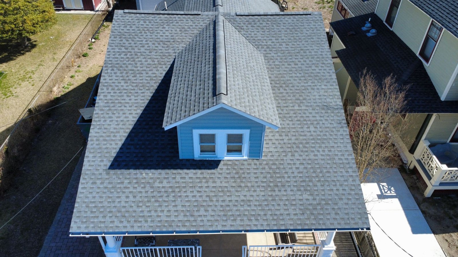 After — top-down aerial of Cape Cod with new dark charcoal shingles — Shelby Roofing Services NJ