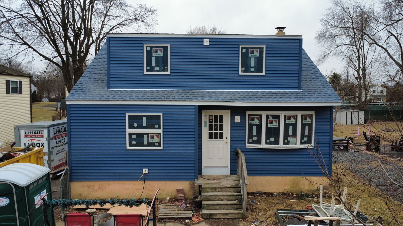 After — front of renovated gambrel cape with new blue siding and dark shingles — Shelby Roofing Services NJ