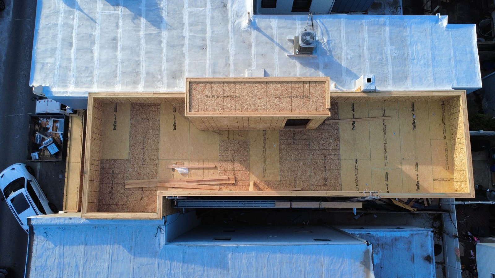 In-progress — top-down aerial of commercial building with new OSB roof deck being installed, NJ