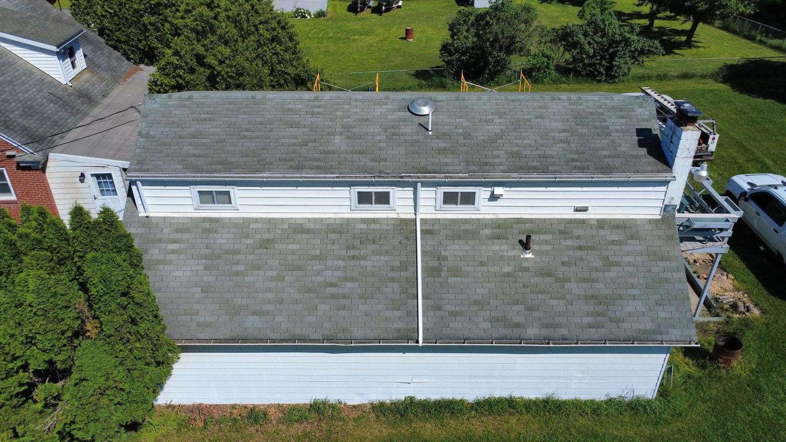 Before — side aerial of white ranch with old shingles, PA