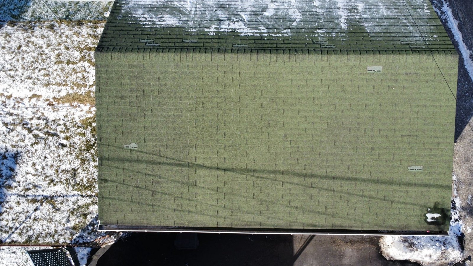 Before — side aerial of rowhouse with old worn shingles and snow on flat porch roof, PA