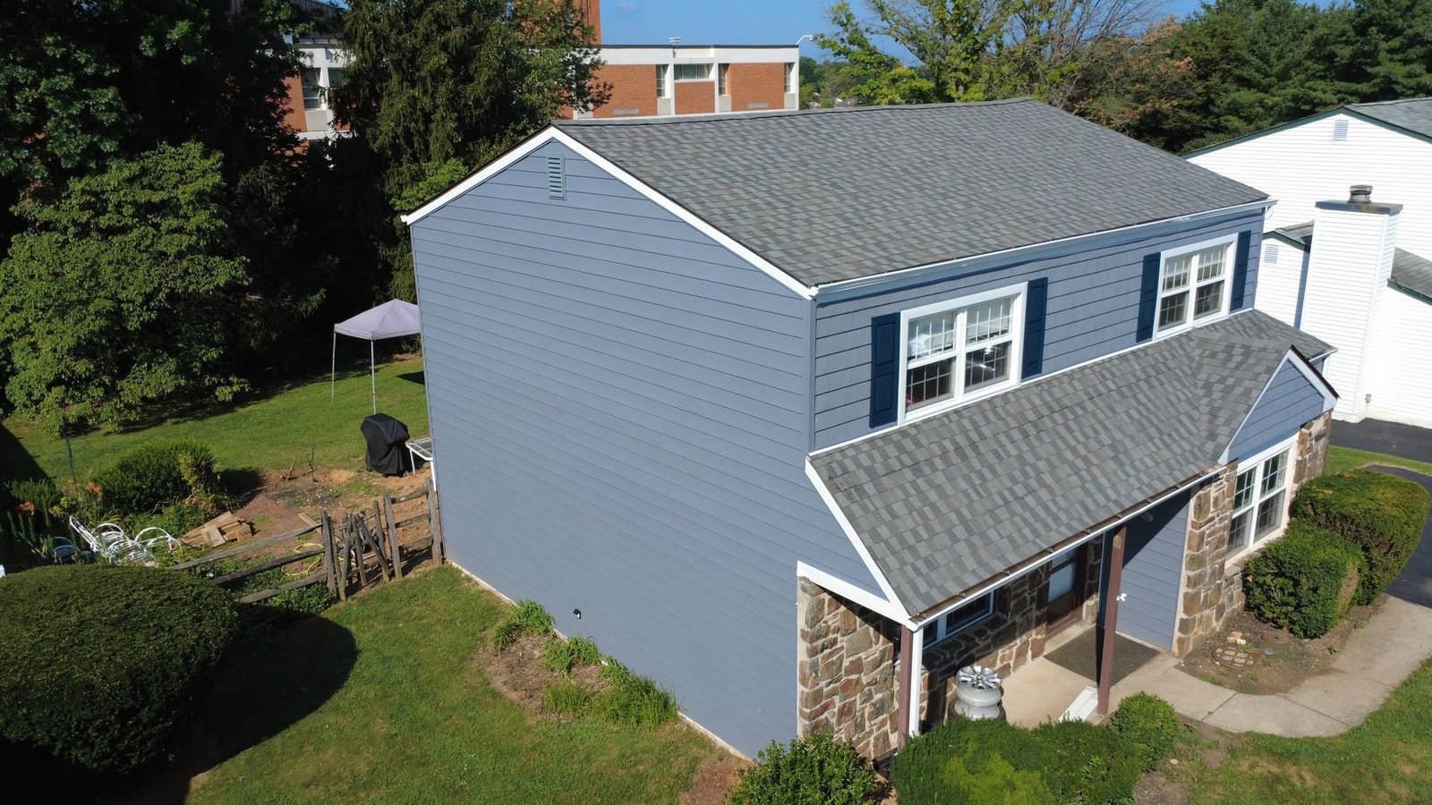 After — side aerial of completed stone colonial — Shelby Roofing Services PA