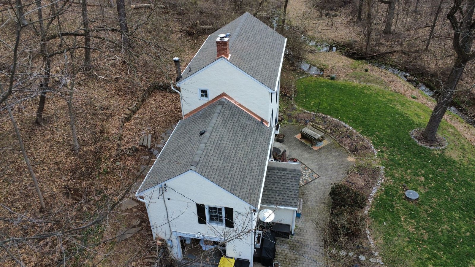 After — aerial of completed white cottage with new gray shingles — Shelby Roofing Services PA