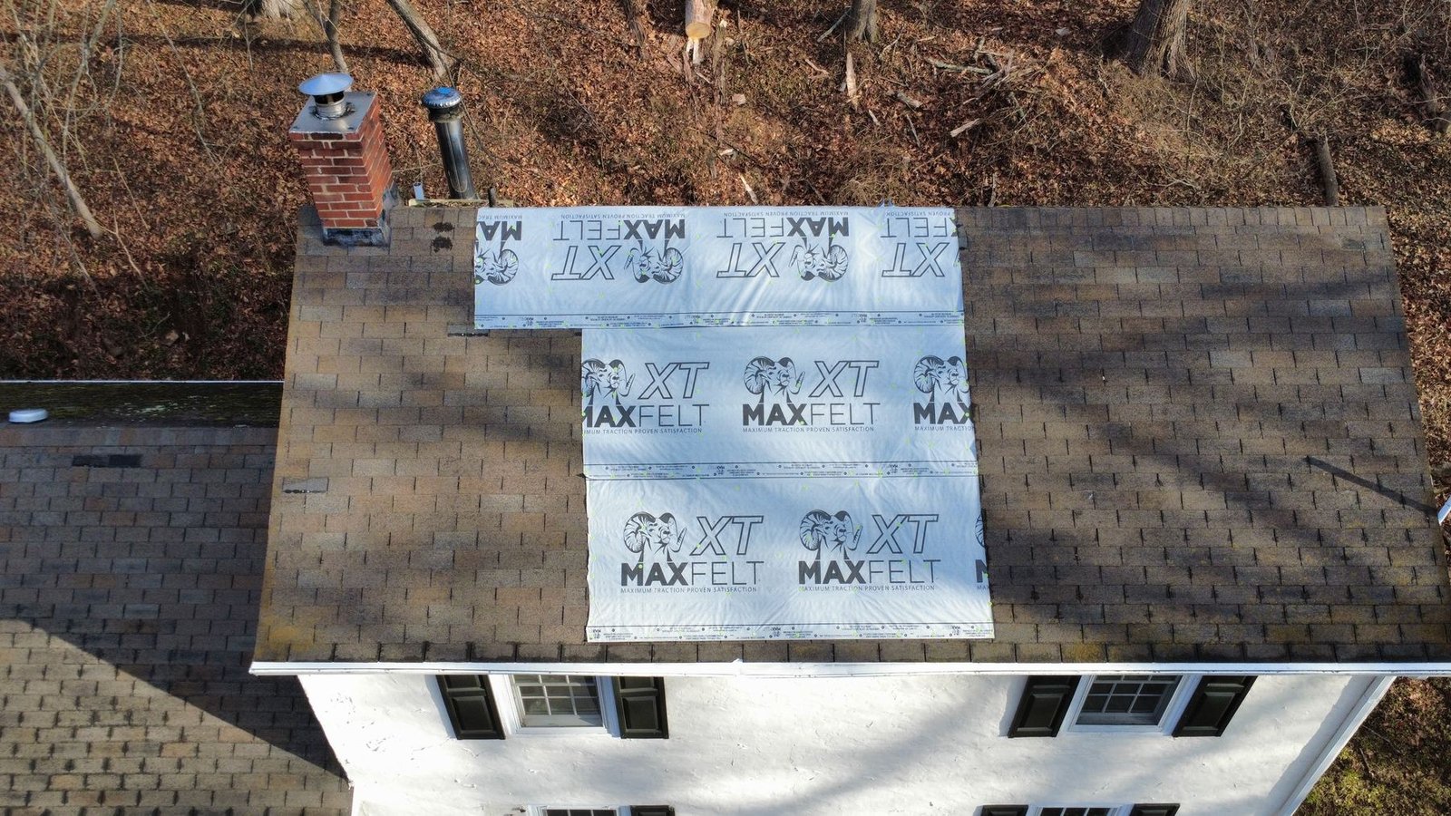 Before — front view of white cottage with moss-covered shingles, PA