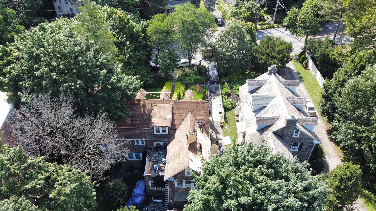 Shelby Roofing Services crew mid tear-off on brick colonial, PA