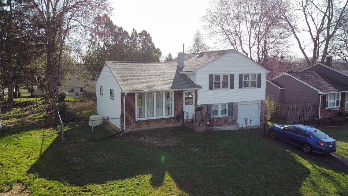 Before — full front facade aerial showing complete house with old shingles, lower addition and garage visible, PA