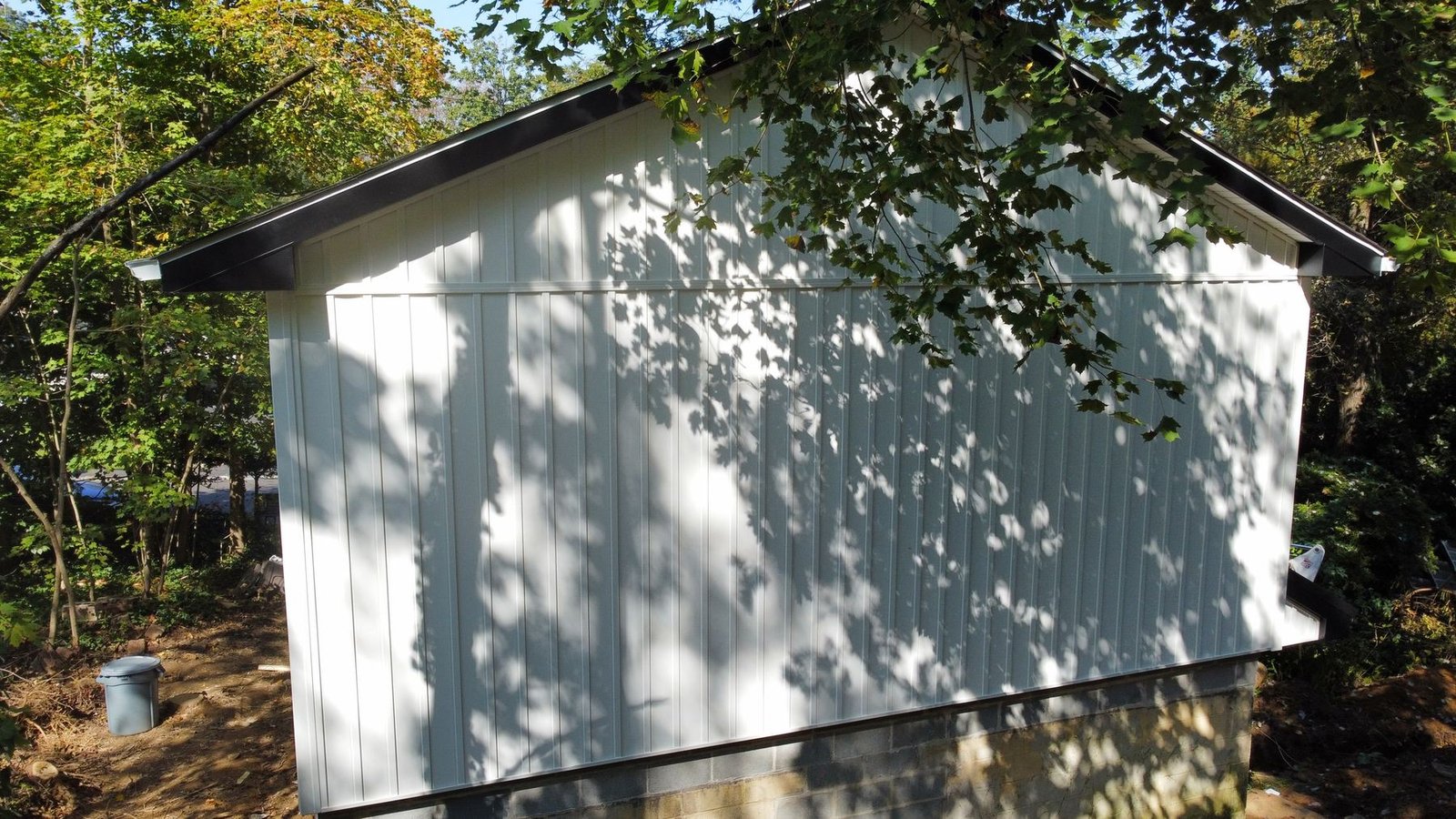 After — left side of completed structure with new white siding and charcoal roof — Shelby Roofing Services PA