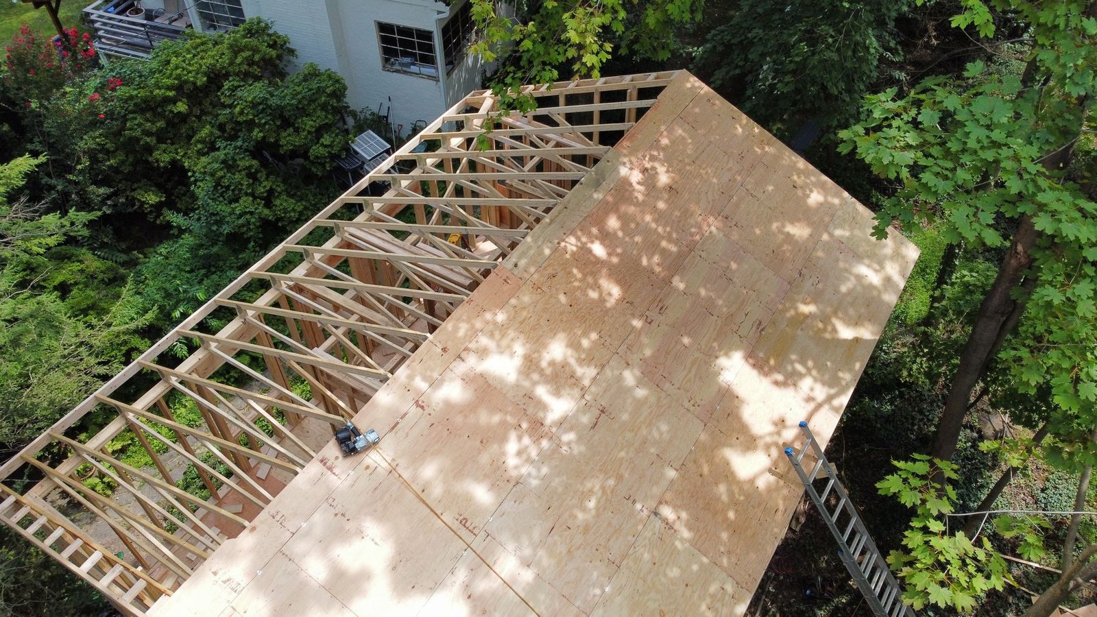 In-progress — top-down aerial showing roof trusses and new OSB decking being installed, PA