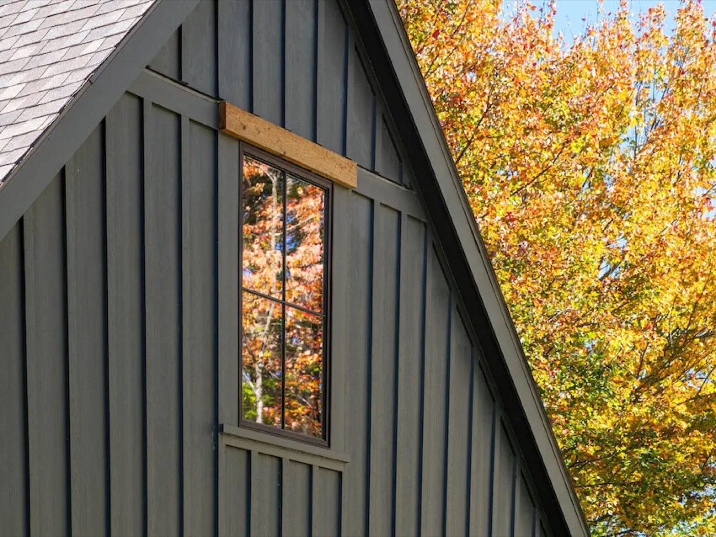 Completed composite siding installation — charcoal board and batten on a gabled home — Shelby Roofing Services